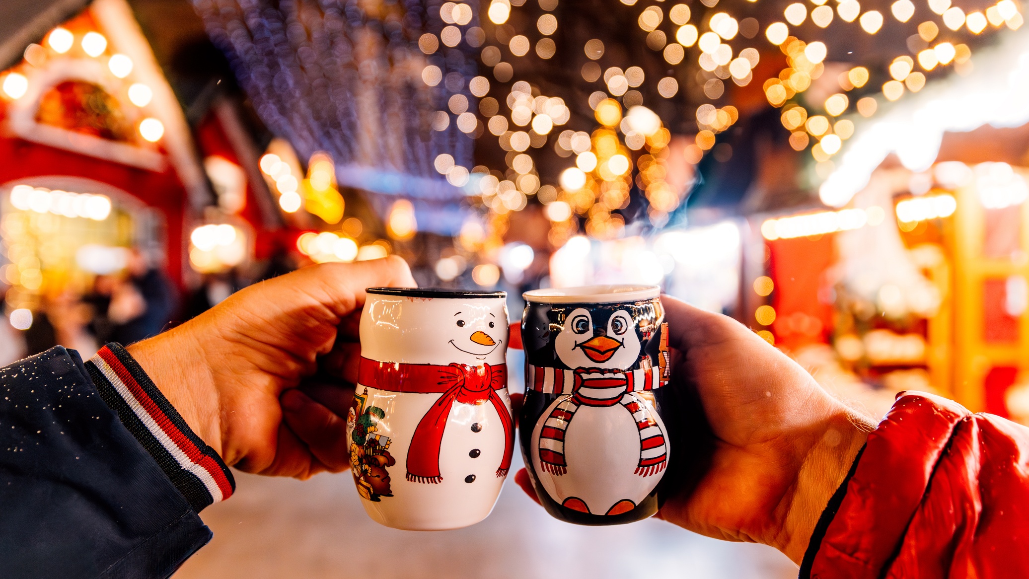 Bögrékkel koccintanak egy adventi vásáron