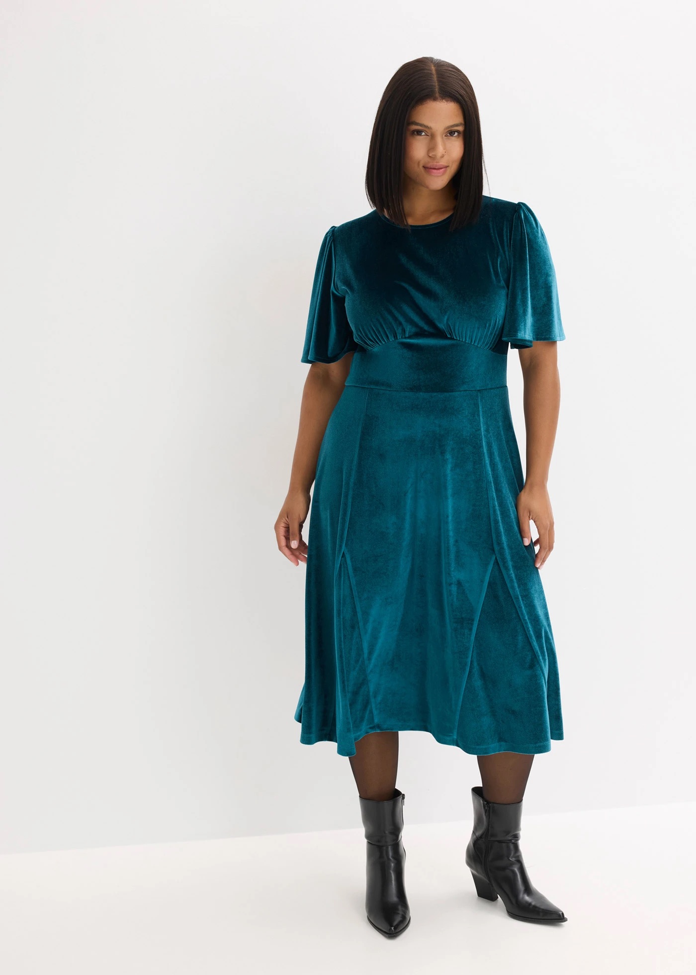 Zöld alkalmi ruhát viselő modell