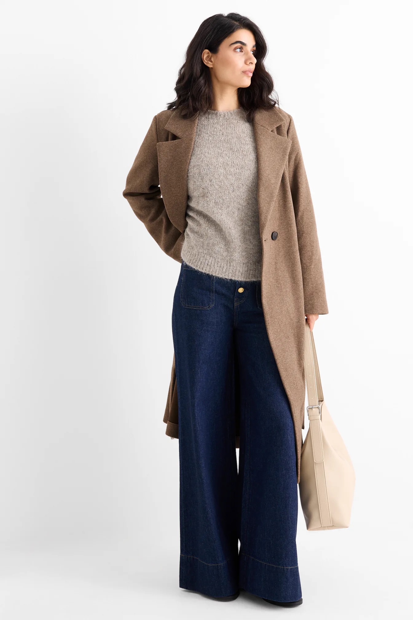 Hosszú szövetkabátot viselő modell