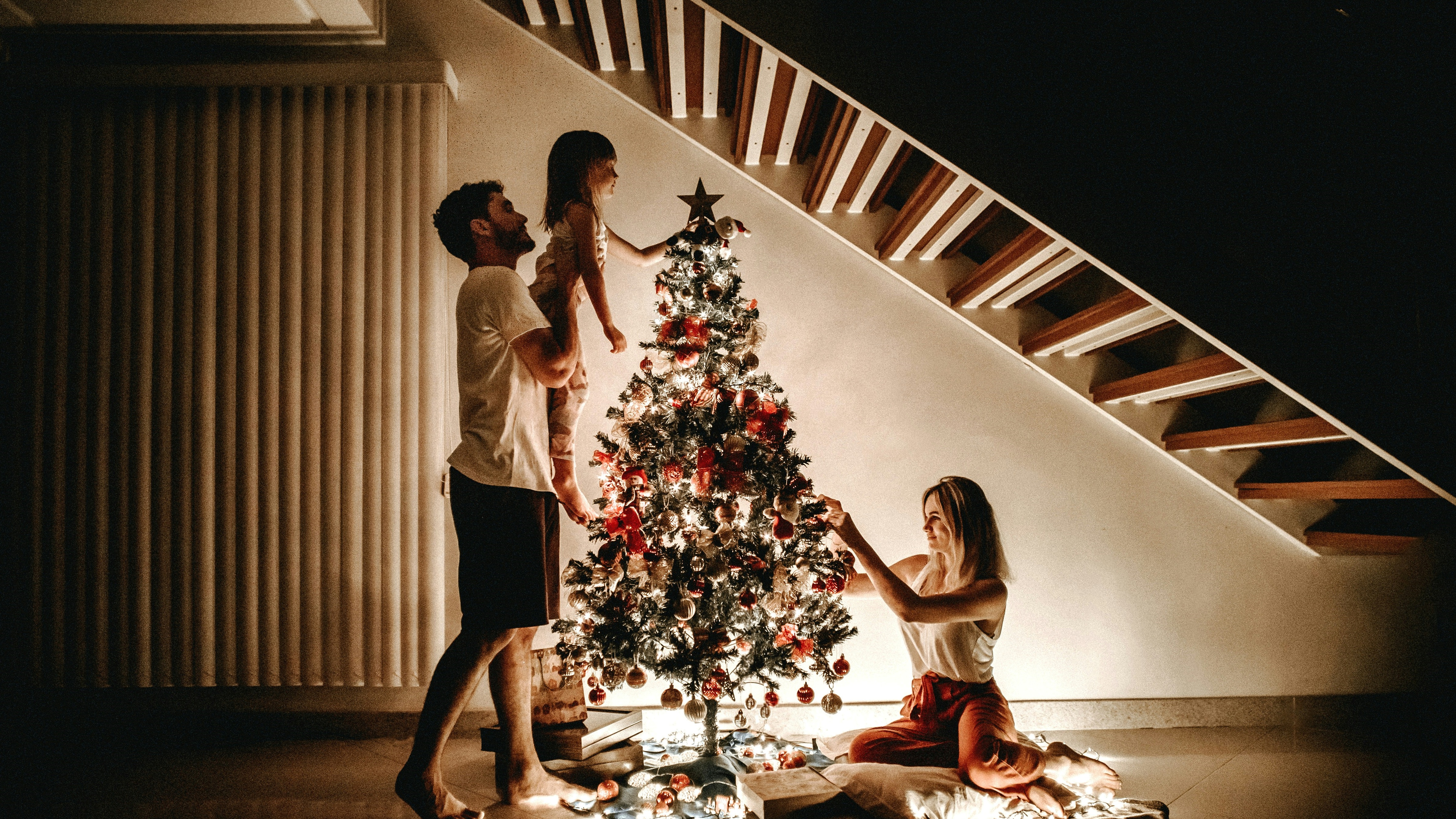 karácsonyfát díszít egy háromtagú család