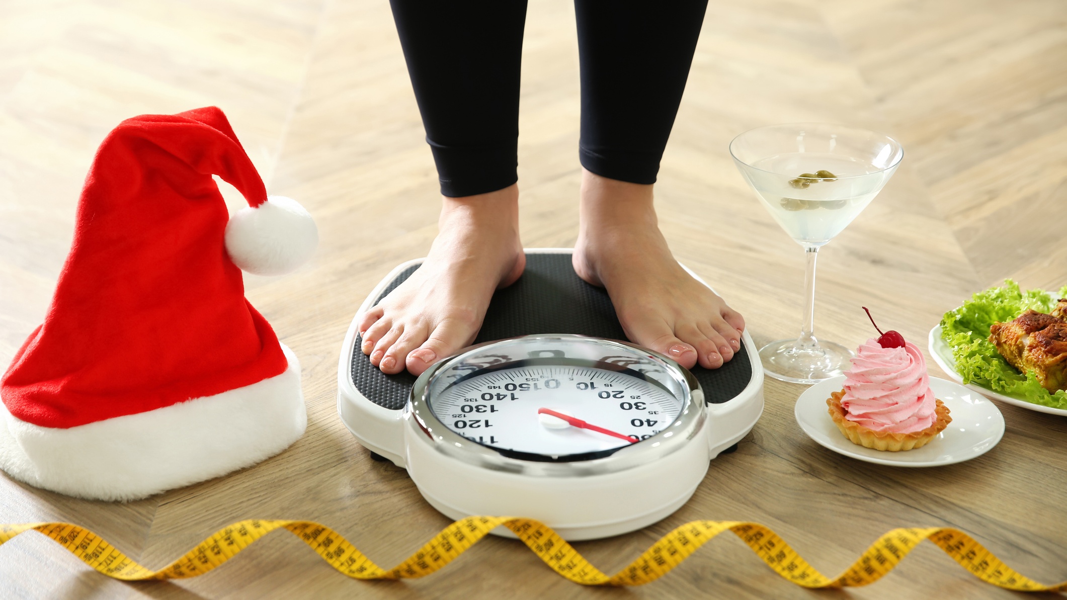 Nő áll mikulássapka mellett a mérlegen