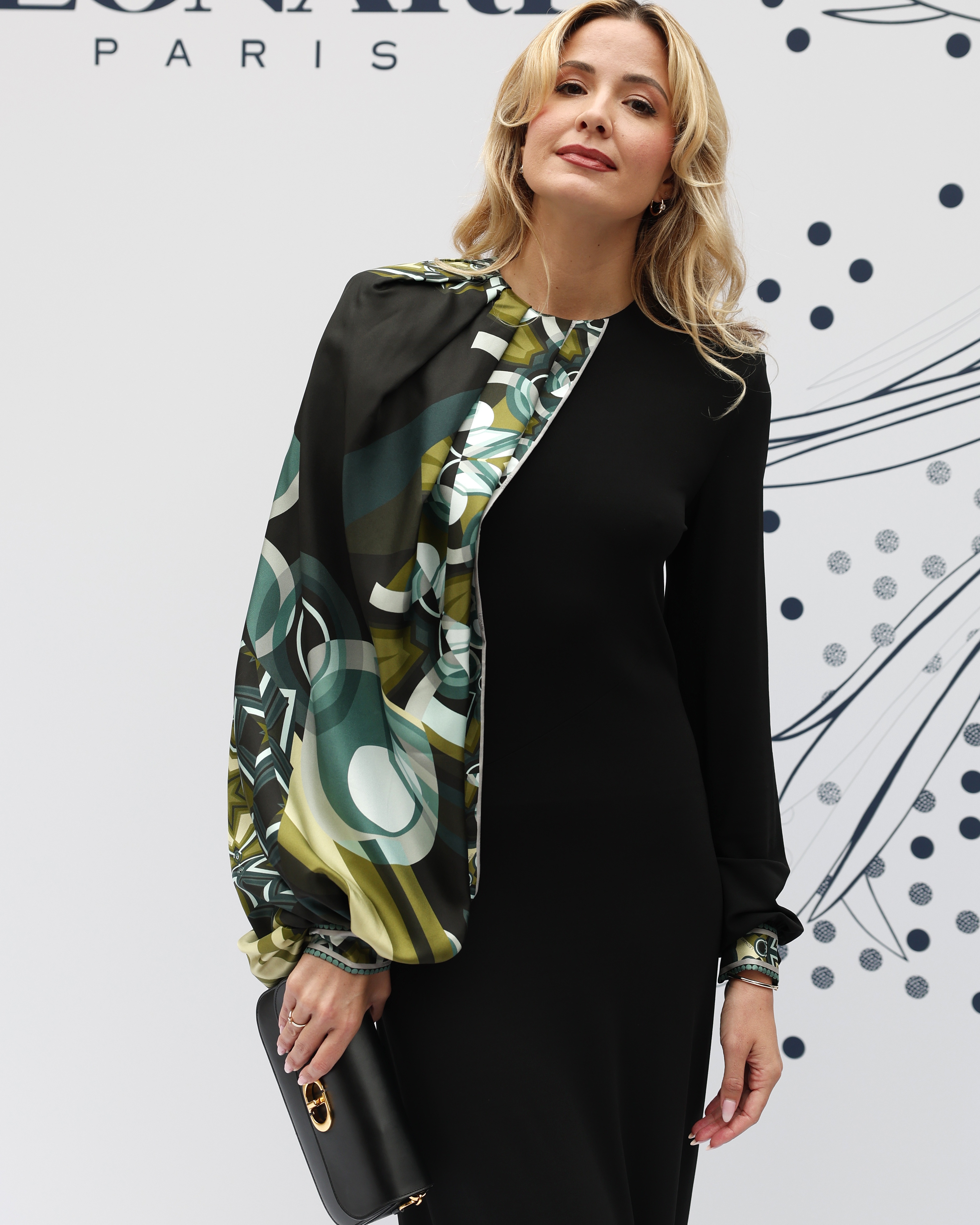 Nő fekete nadrágkosztümben, mintás selyemsállal