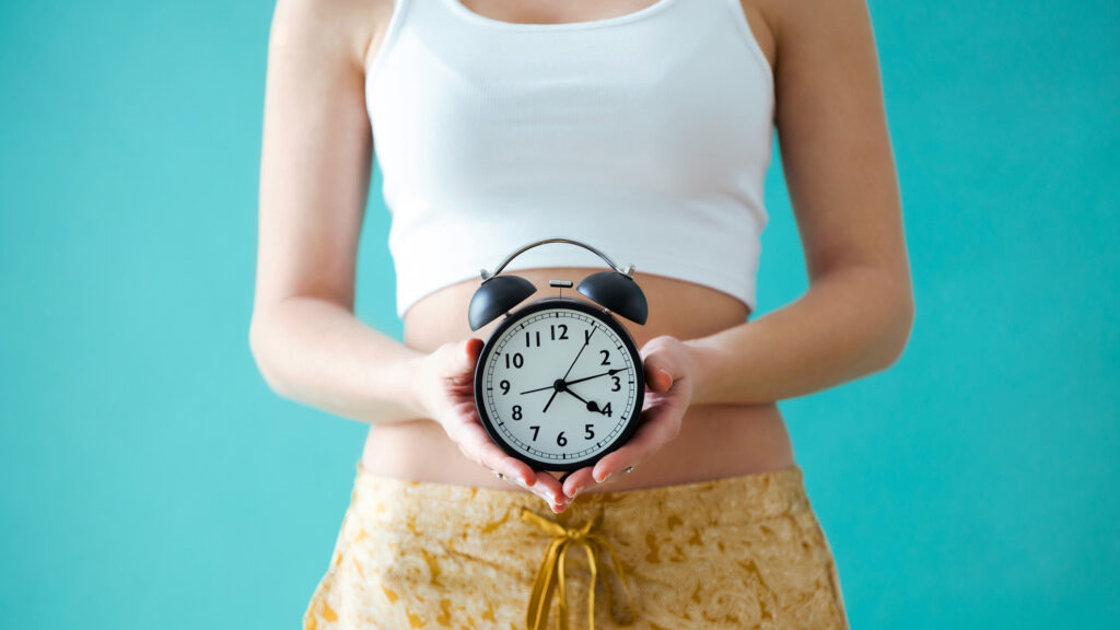 Órát tart a kezében egy nő