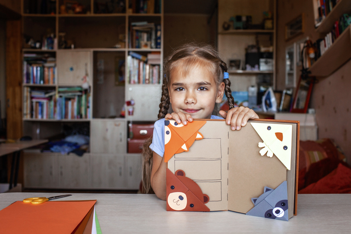 Kislány papír könyvjelzőkkel