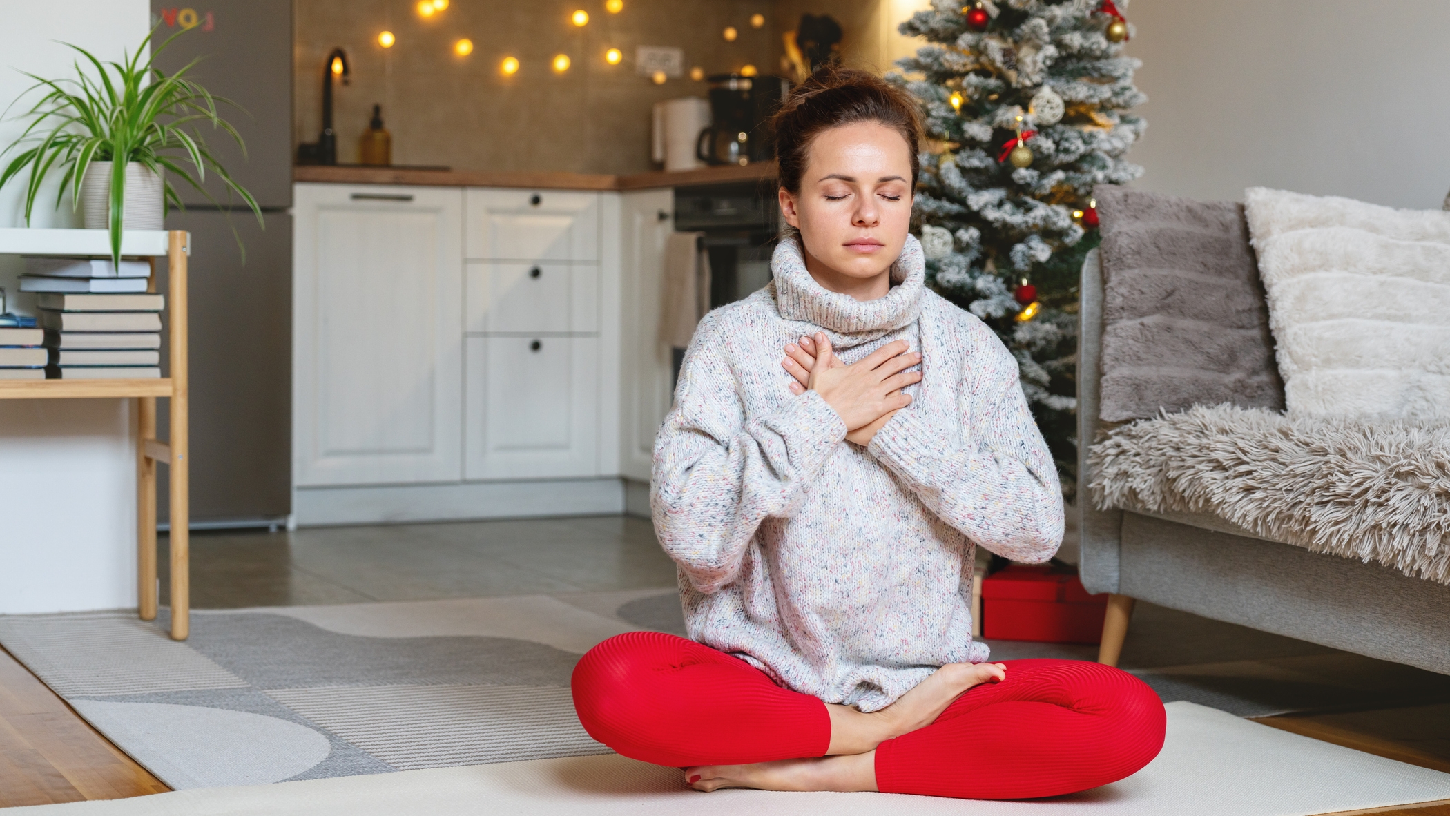 Légzőgyakorlatot végző nő a karácsonyfa előtt