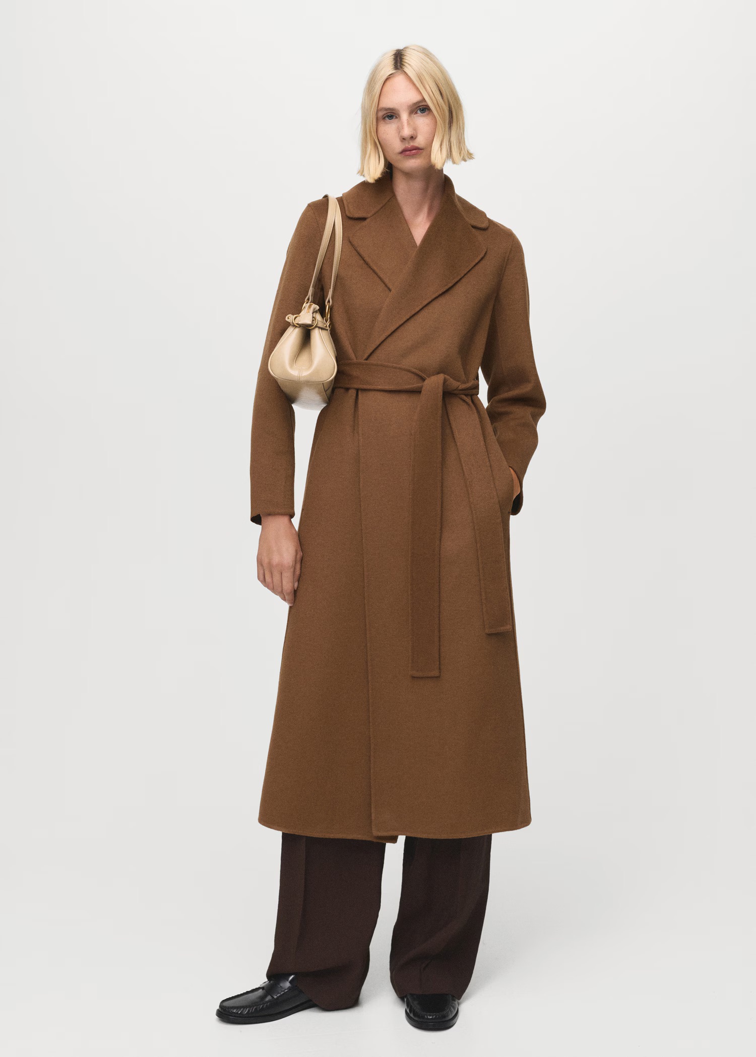 Hosszú szövetkabátot viselő modell