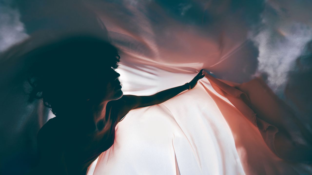 Női sziluett kendővel a szélben