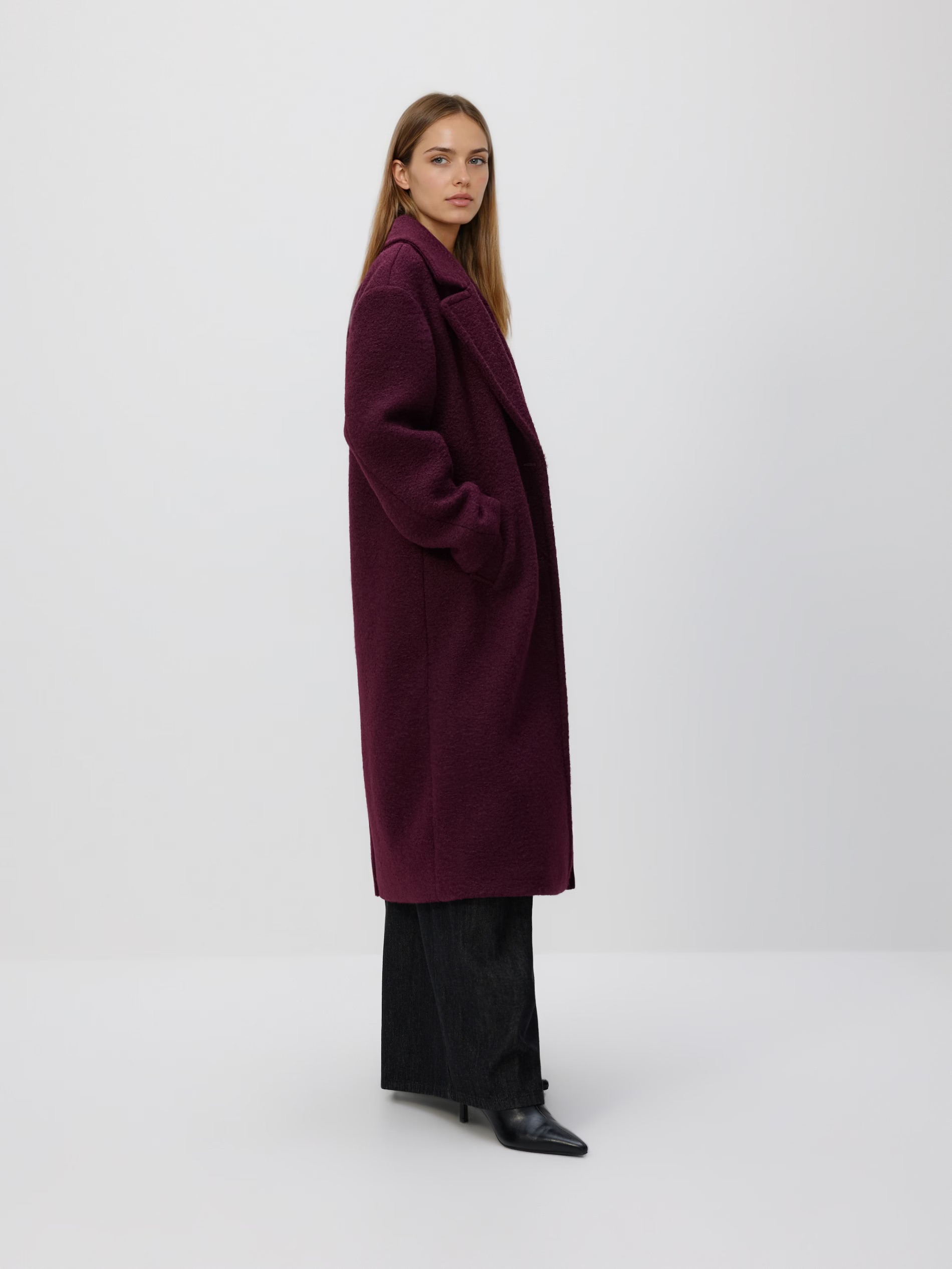 Hosszú szövetkabátot viselő modell