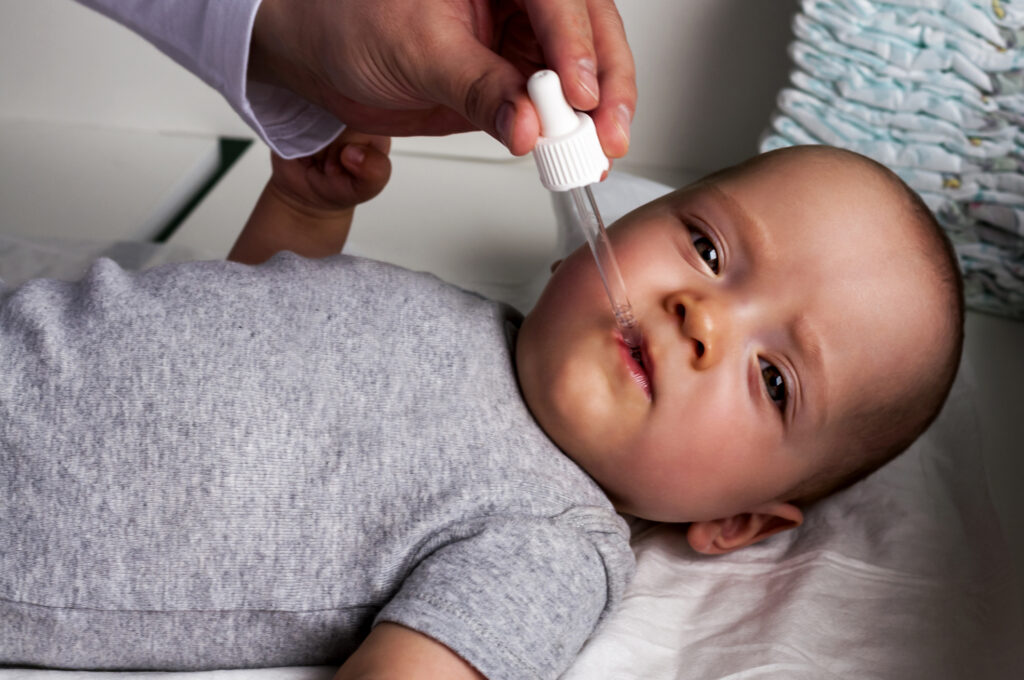 Vitamin cseppeket kap egy csecsemő