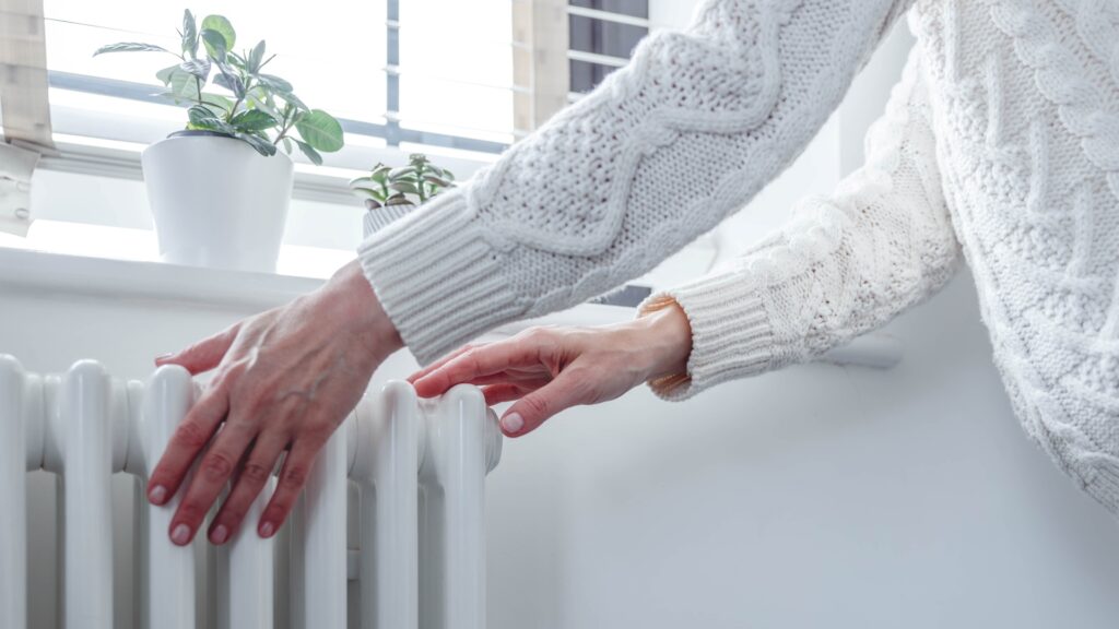 Egy nő a radiátort ellenőrzi,