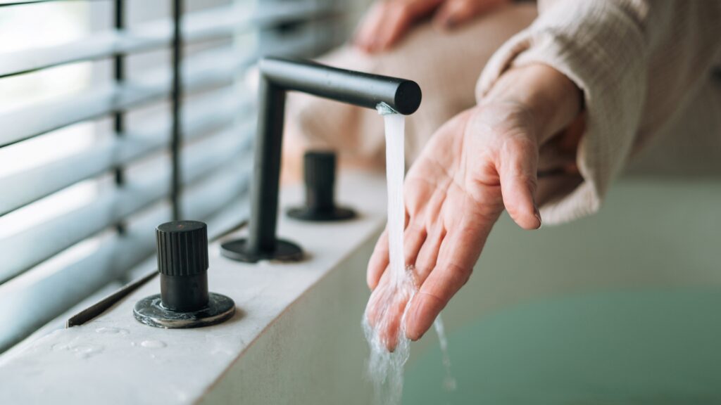 Idősebb nő fürdéshez készül.