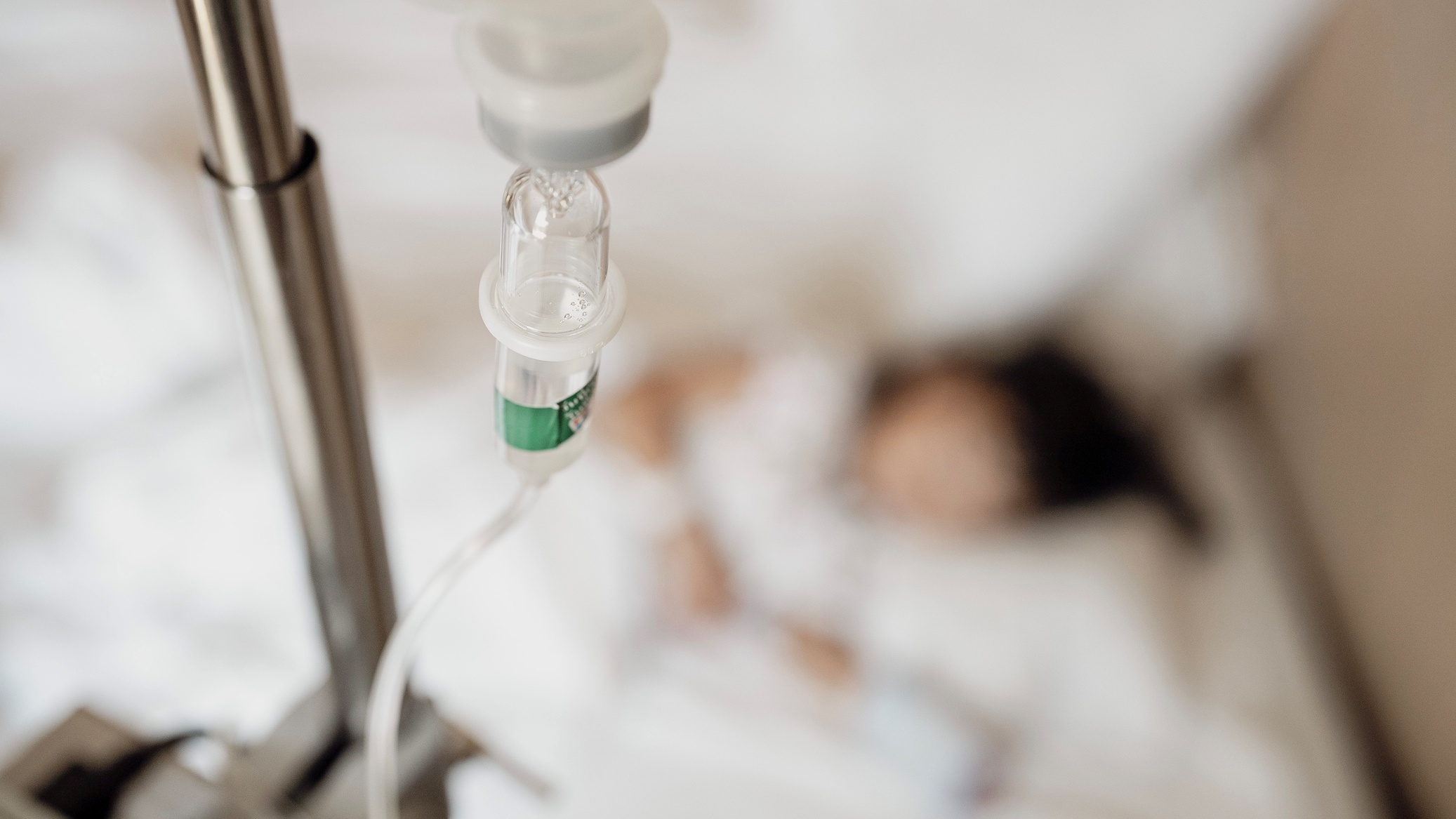 Gyerek kórházban fekszik az ágyon, felette infúzió