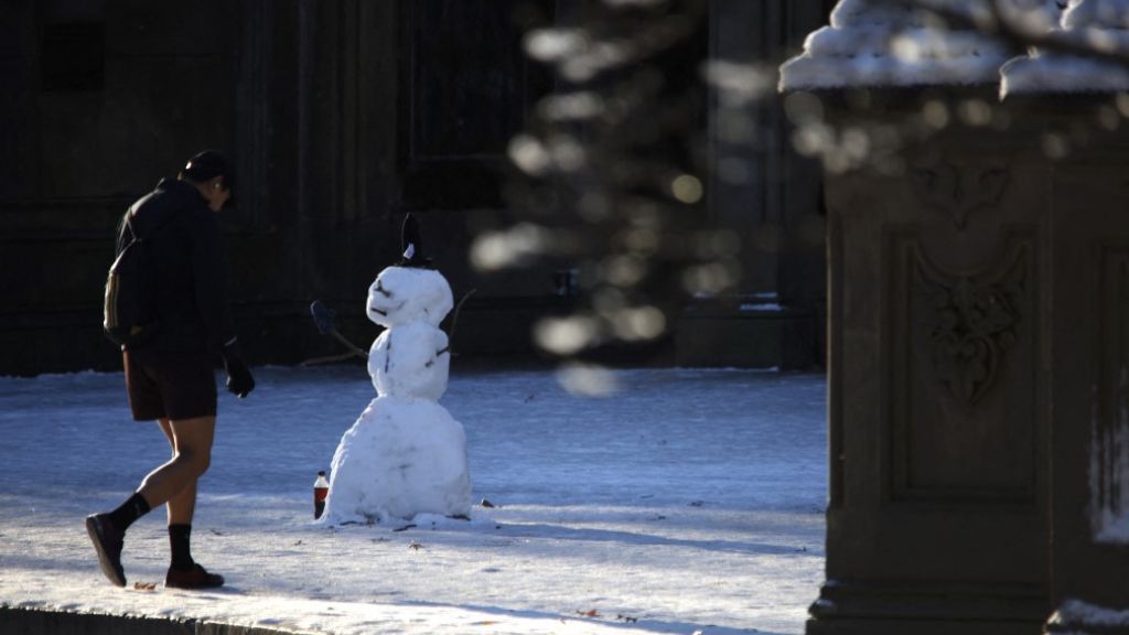 New York Centrál Parkjában hóember előtt sétál egy ember