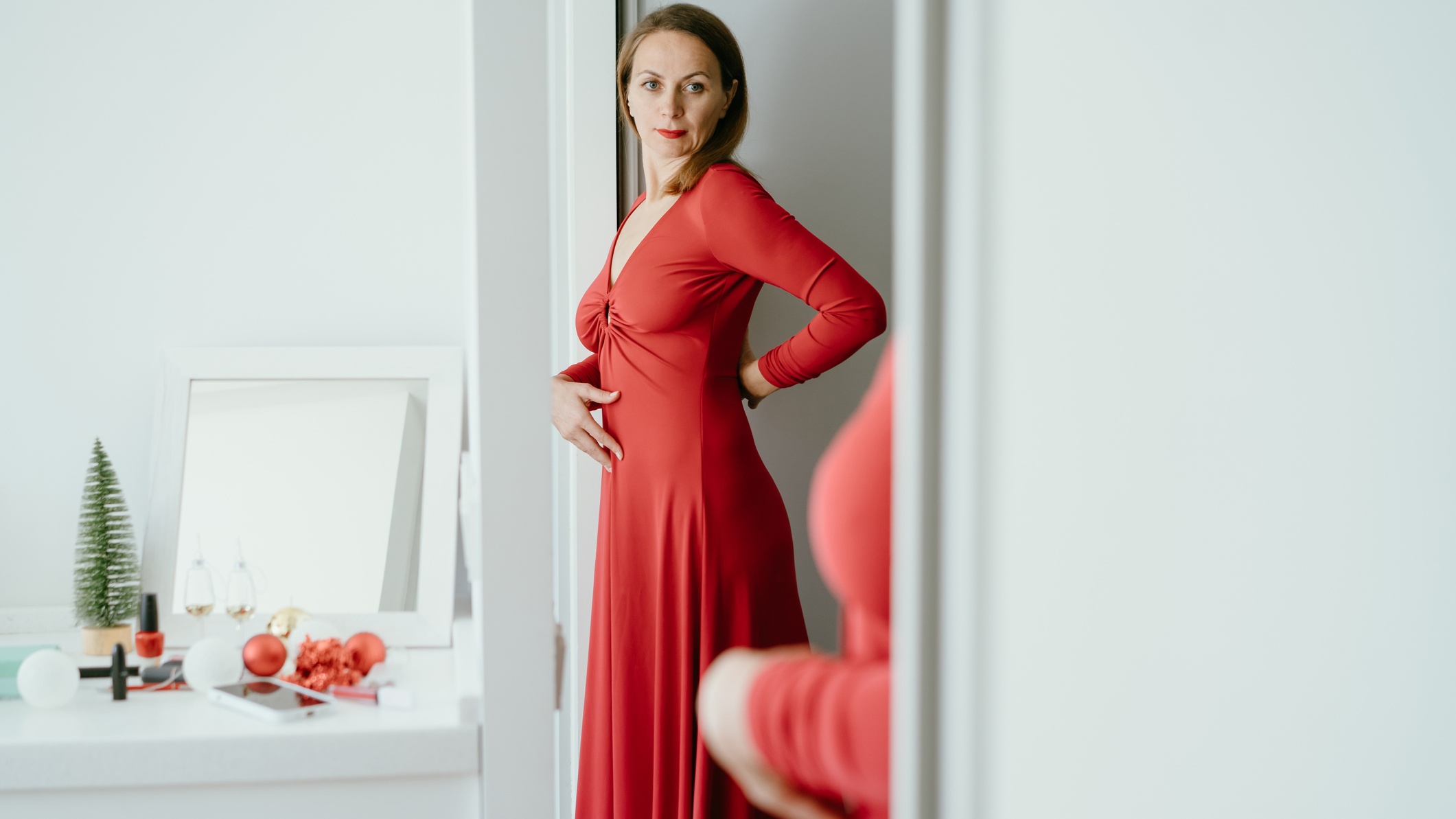 Nő a tükör előtt piros ruhában