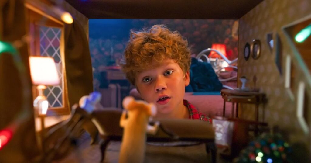 Egy kisfiú egy egeret néz a Karácsonyi egércsata című filmben.