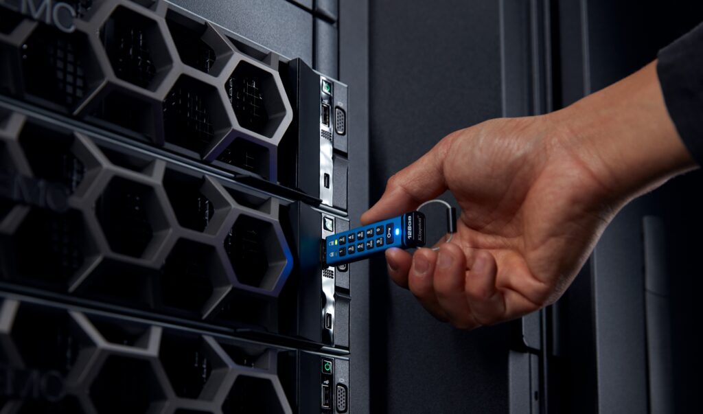 Egy ember kéz bedug egy pendrive-ot egy számítógépbe