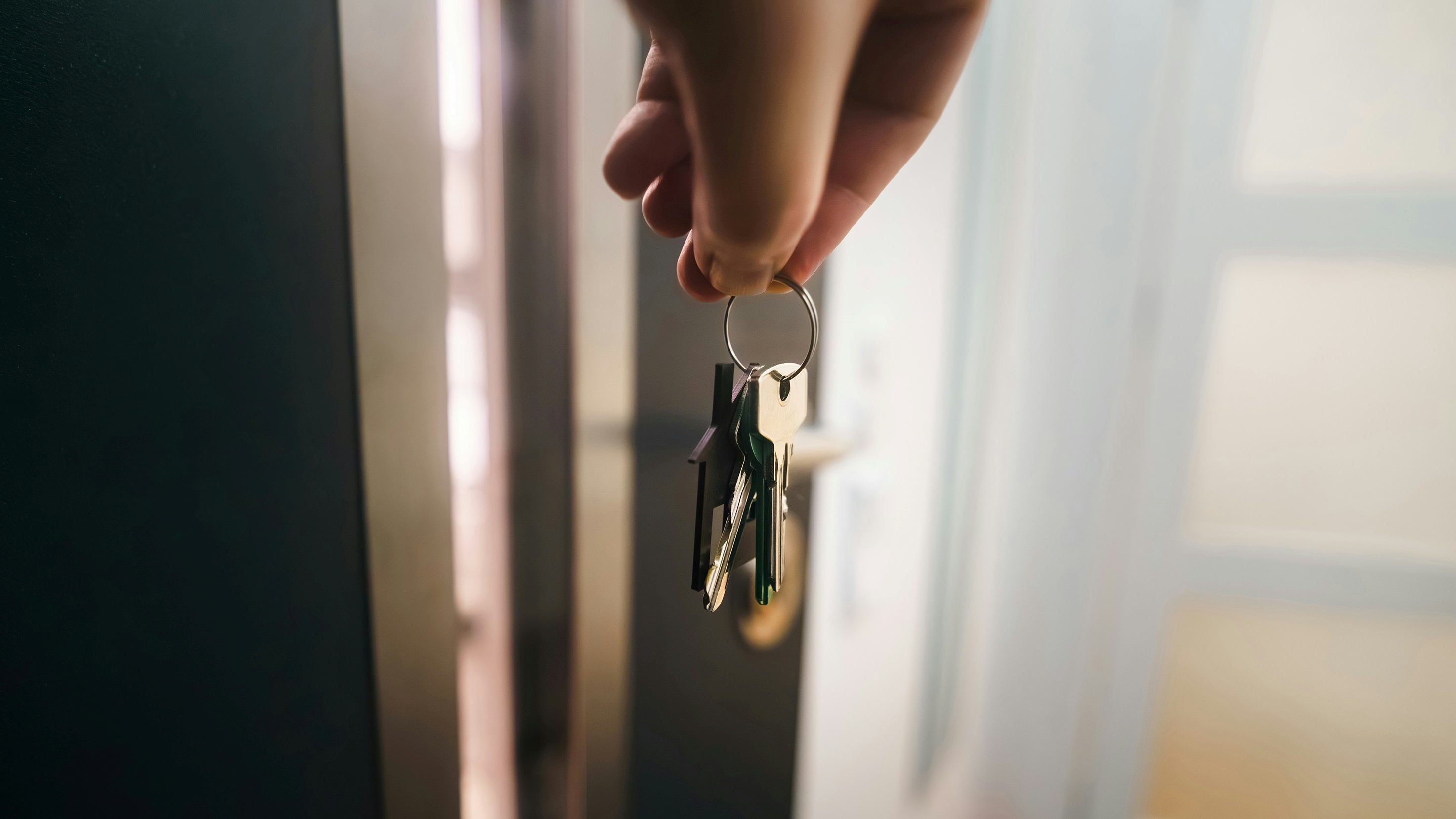 Lakáskulcsot fog egy férfi a kezében 