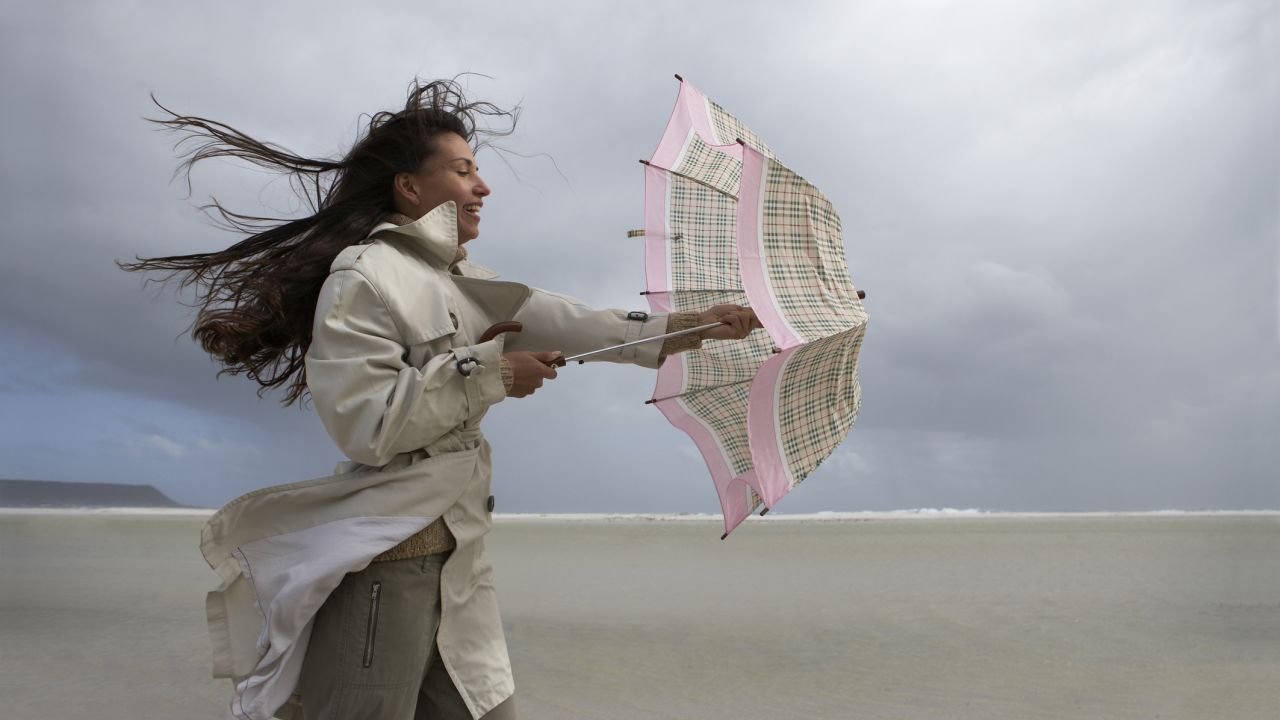 Nő ernyővel a szélben