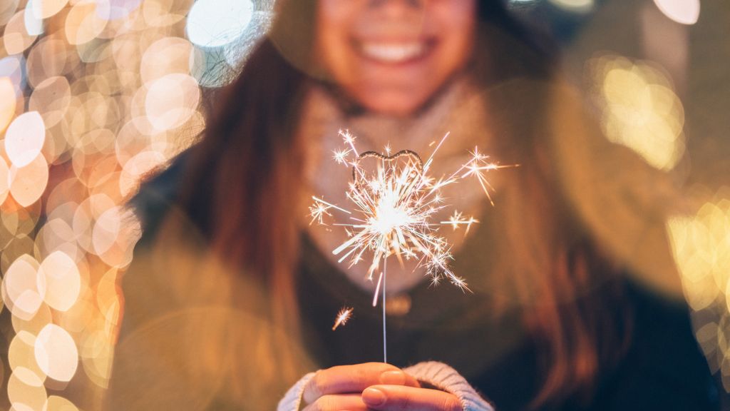 Karácsonyi fényekben csillagszórózó lány