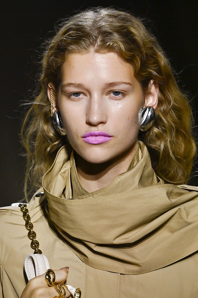 Élénk színű rúzst viselő modell a kifutón