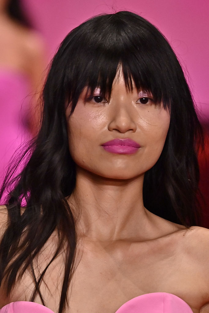 Élénk színű rúzst viselő modell a kifutón