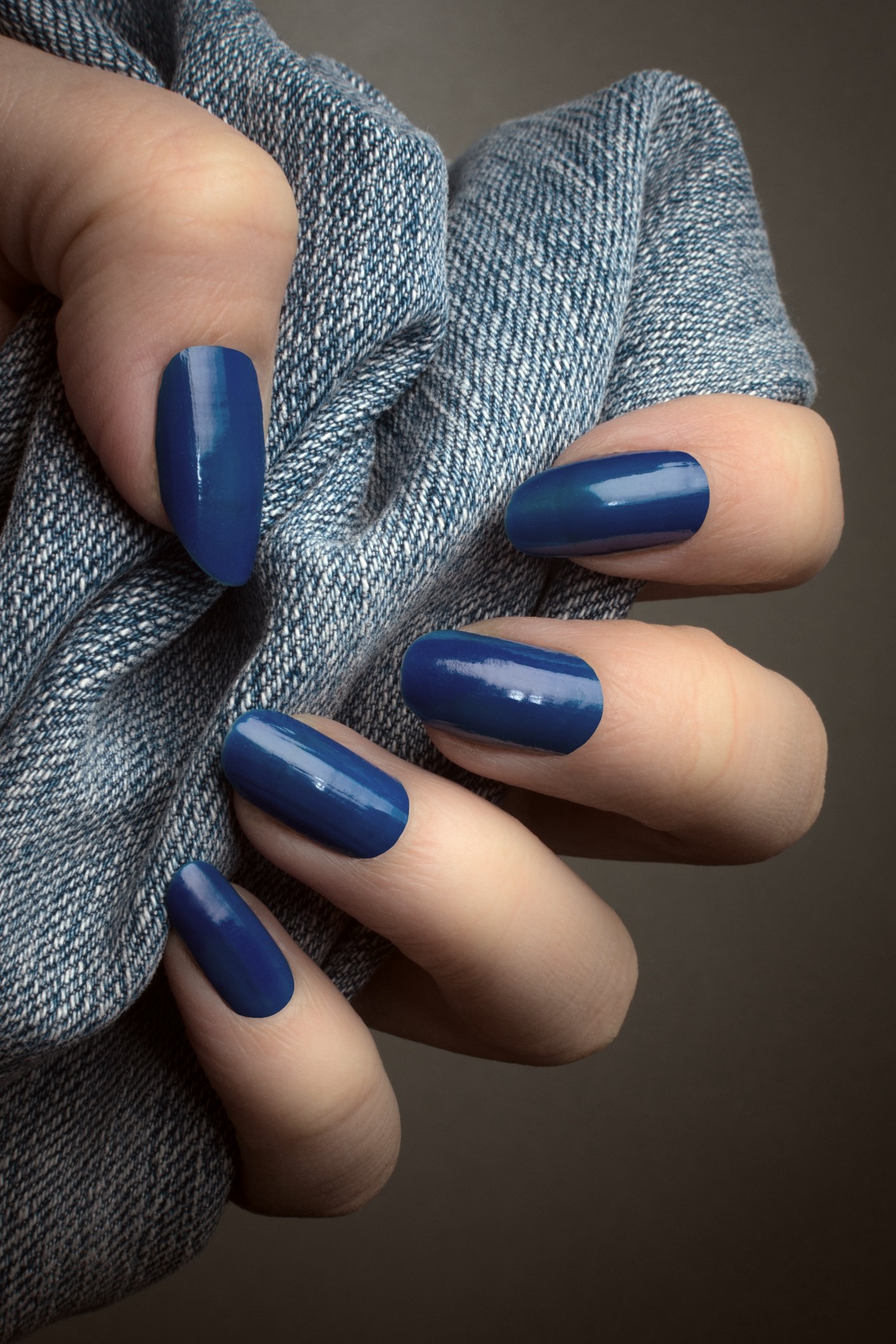 Farmerkék körömlakk női kézen