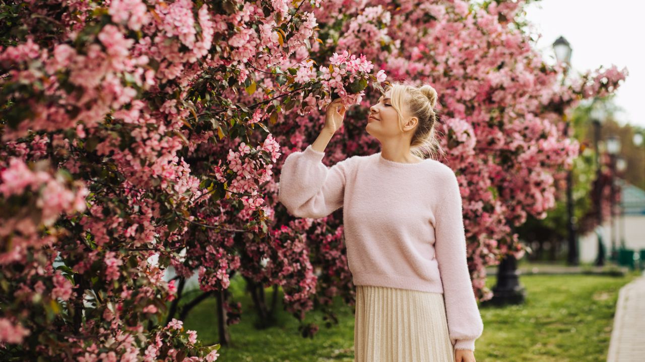 Hölgy tavaszi virágzó bokor mellett