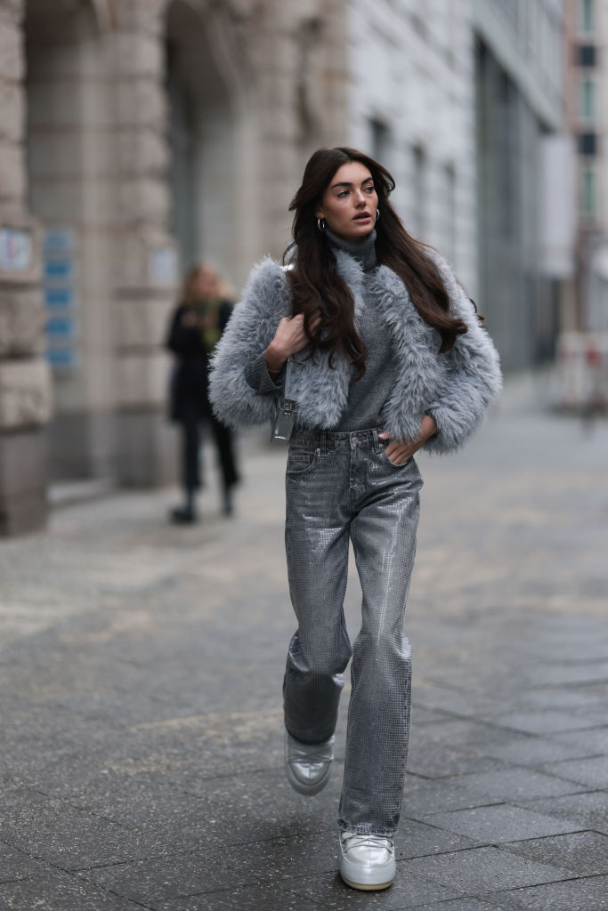 Téli öltözéket és hótaposót viselő nő az utcán