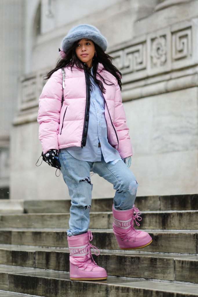 Téli öltözéket és hótaposót viselő nő az utcán