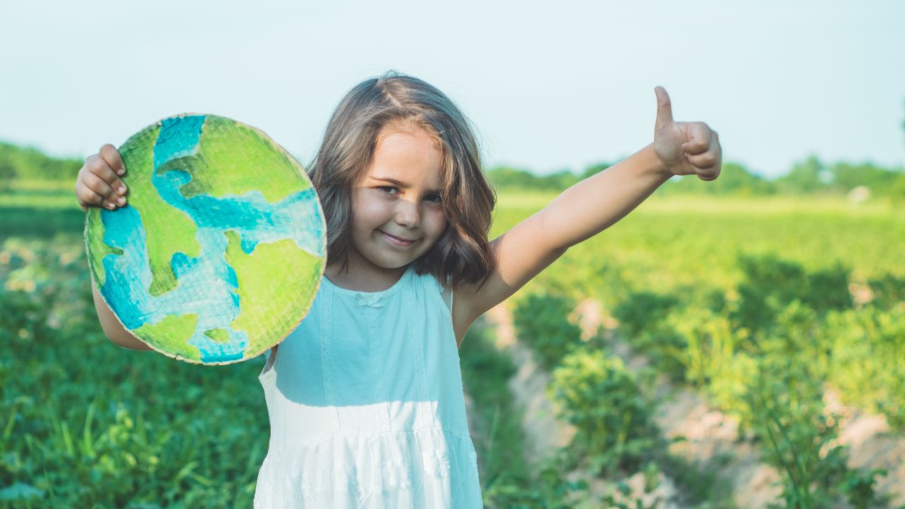 Kislány földgömb táblával