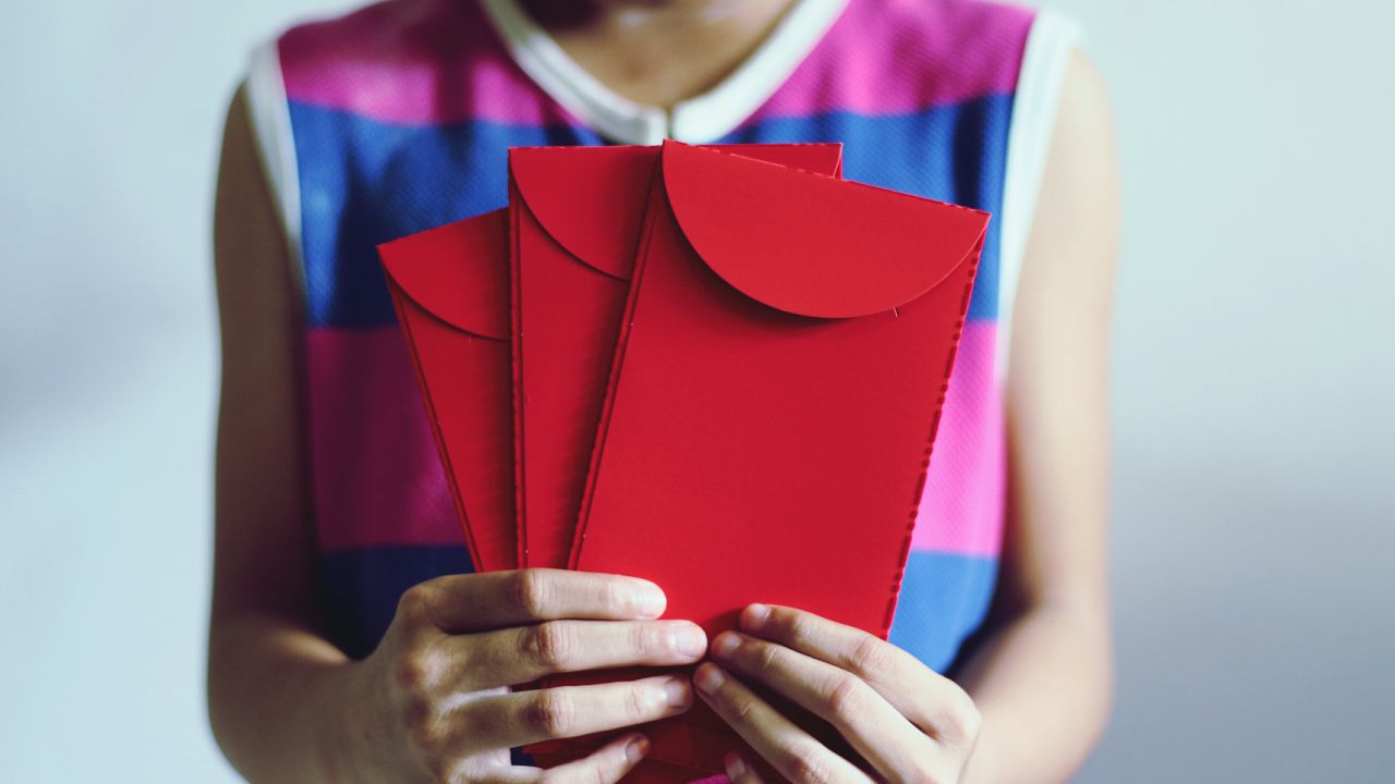 Lány 3 piros borítékot tart