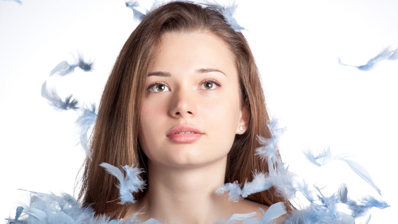 Női portré fehér tollpihékkel