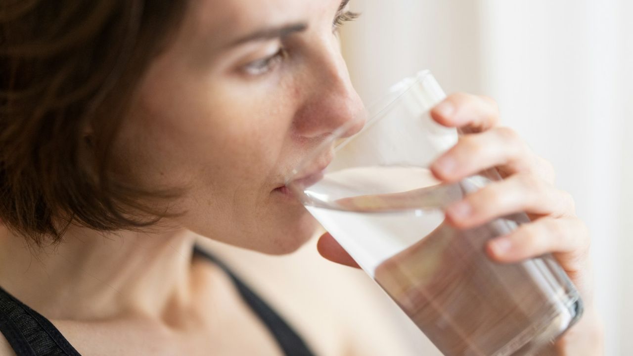 pohár vizet ivó nő, fotó: Unsplash