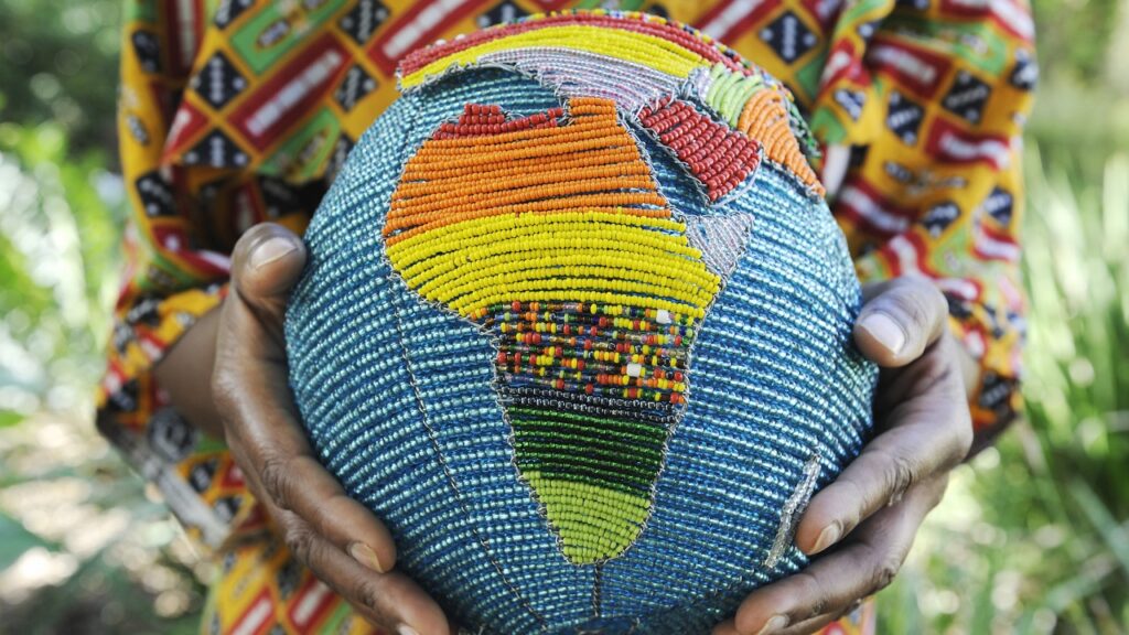 Afrikai nő gyöngyből készült földgömböt tart a kezében