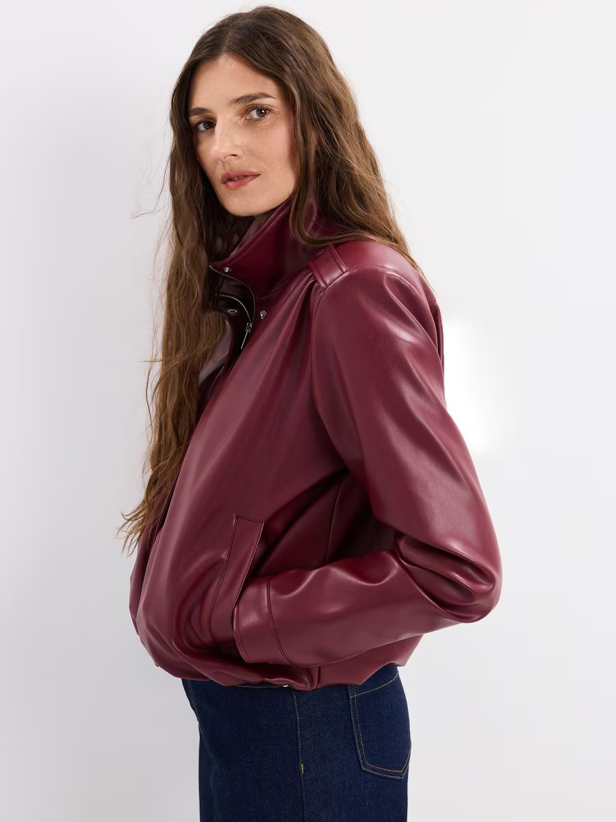 Tölcsérnyakú bőrdzsekit viselő modell