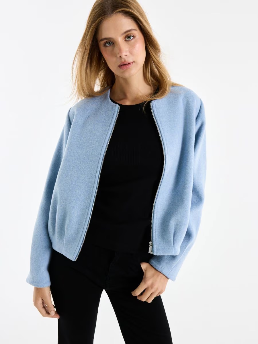 Pasztellszínű bomberdzsekit viselő modellv