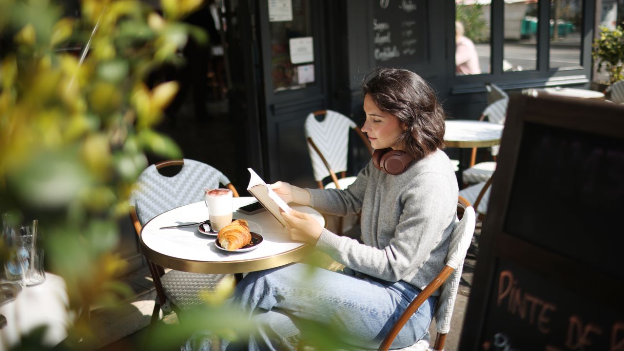 Nő a kávézóban olvas