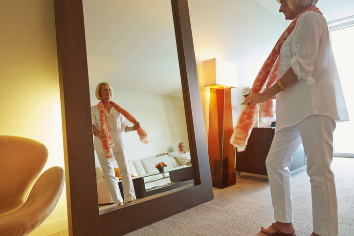 Nő fehér ingben a tükör előtt