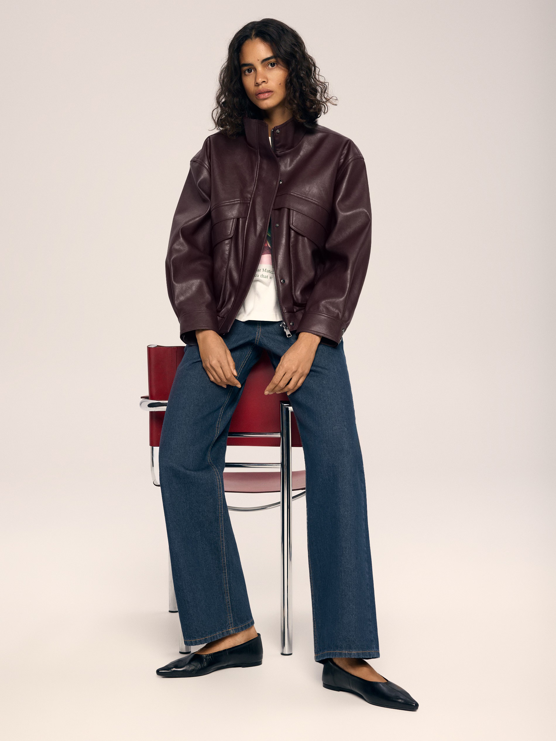 Tölcsérnyakú bőrdzsekit viselő modell