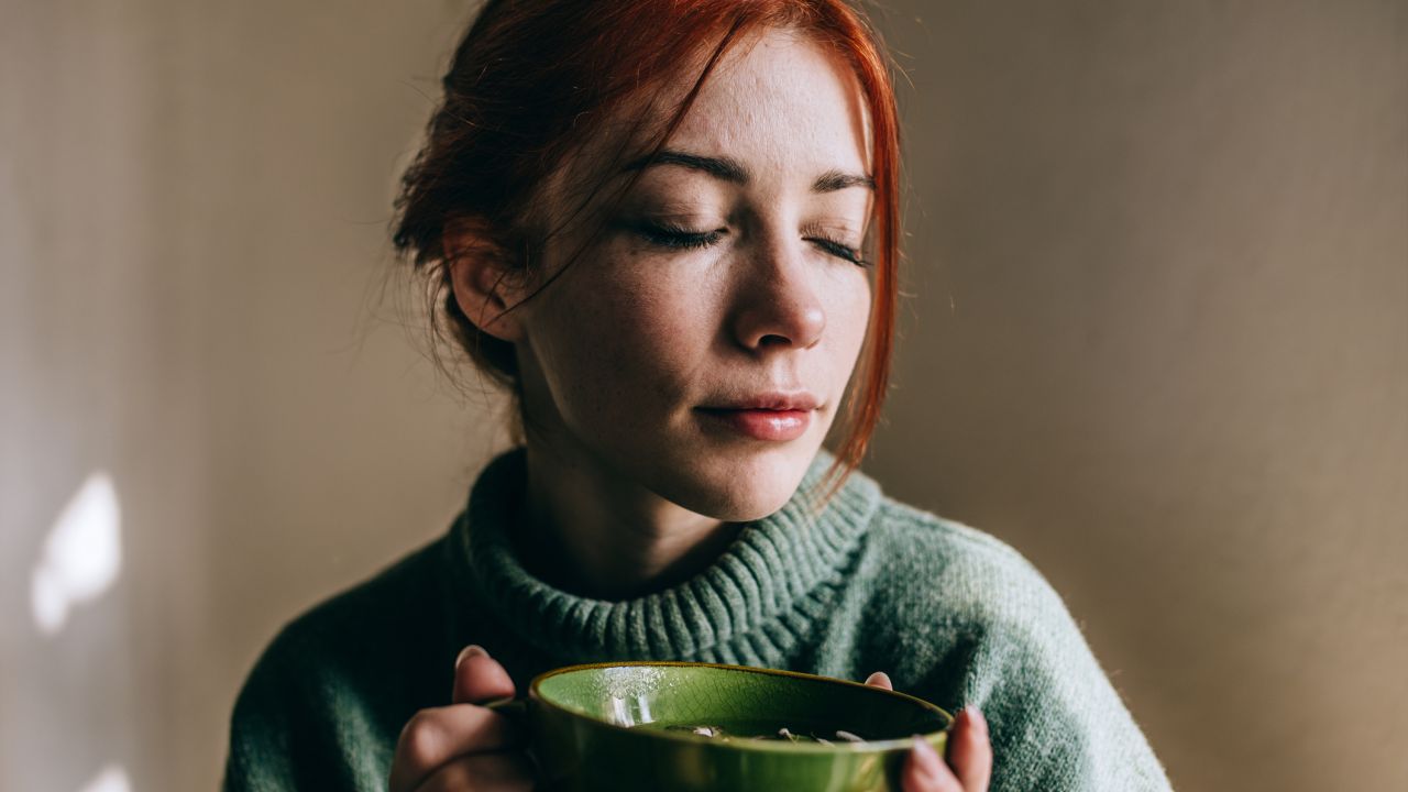 Teáscsészét tartó nő