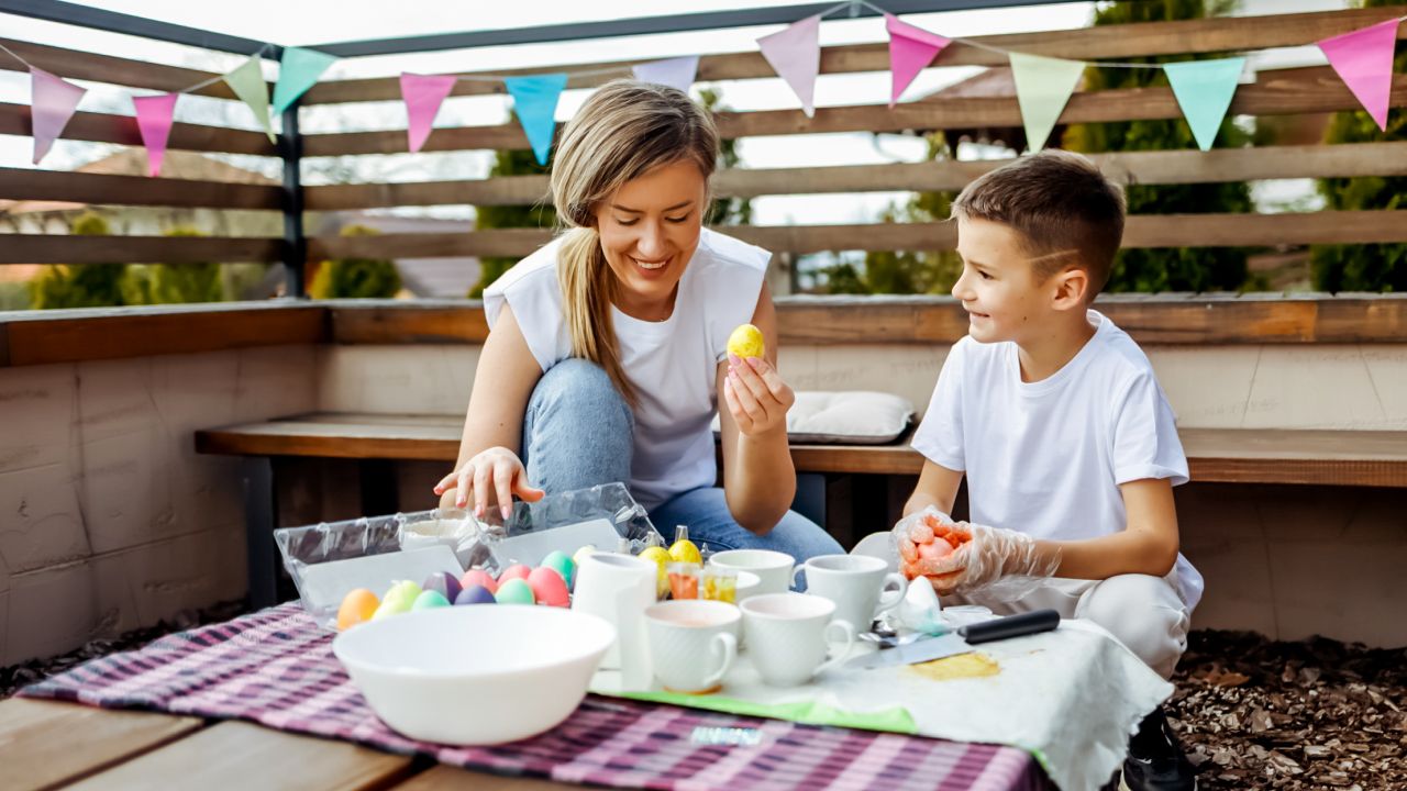 Anya és fiú húsvéti tojást fest a balkonon