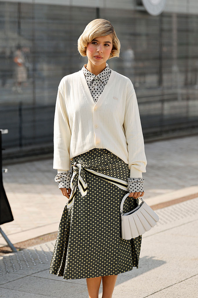 Lágy esésű, enyhén bővülő midi szoknyában egy nő