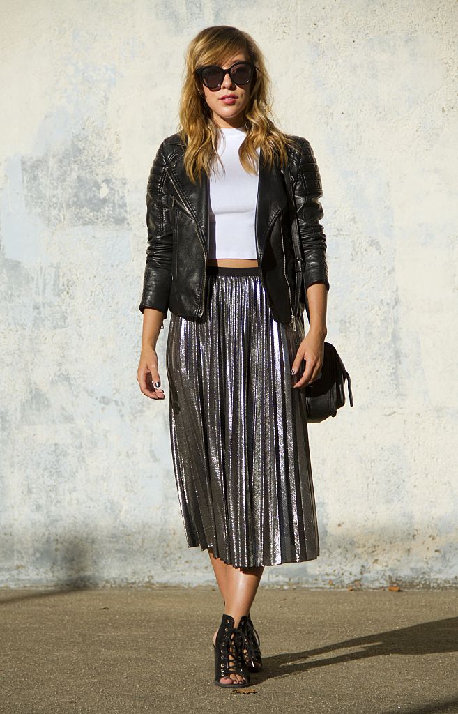 Midi pliszírozott szoknyában áll egy nő