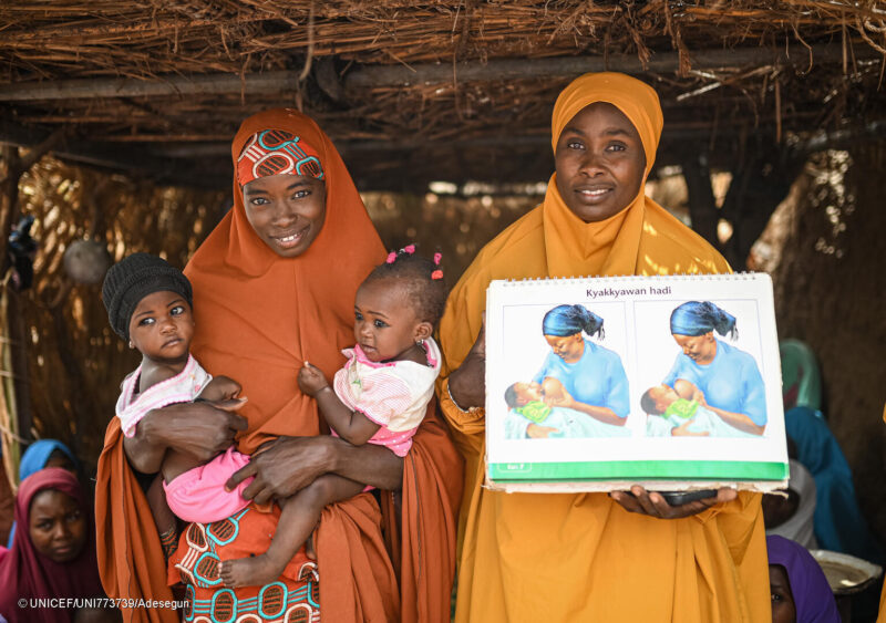 Amina Bulama, ikergyermekes édesanya, és Hannatu Ibrahim táplálkozási tanácsadó Nigériában, Yobe államban. Az UNICEF által támogatott anya–anya támogató csoportokban a nők egymást segítve tanulnak a csecsemők és kisgyermekek helyes táplálásáról, a szoptatásról és az egészséges ételkészítésről, hogy csökkentsék az alultápláltság kockázatát a kisgyermekek körében. Fotó: UNICEF