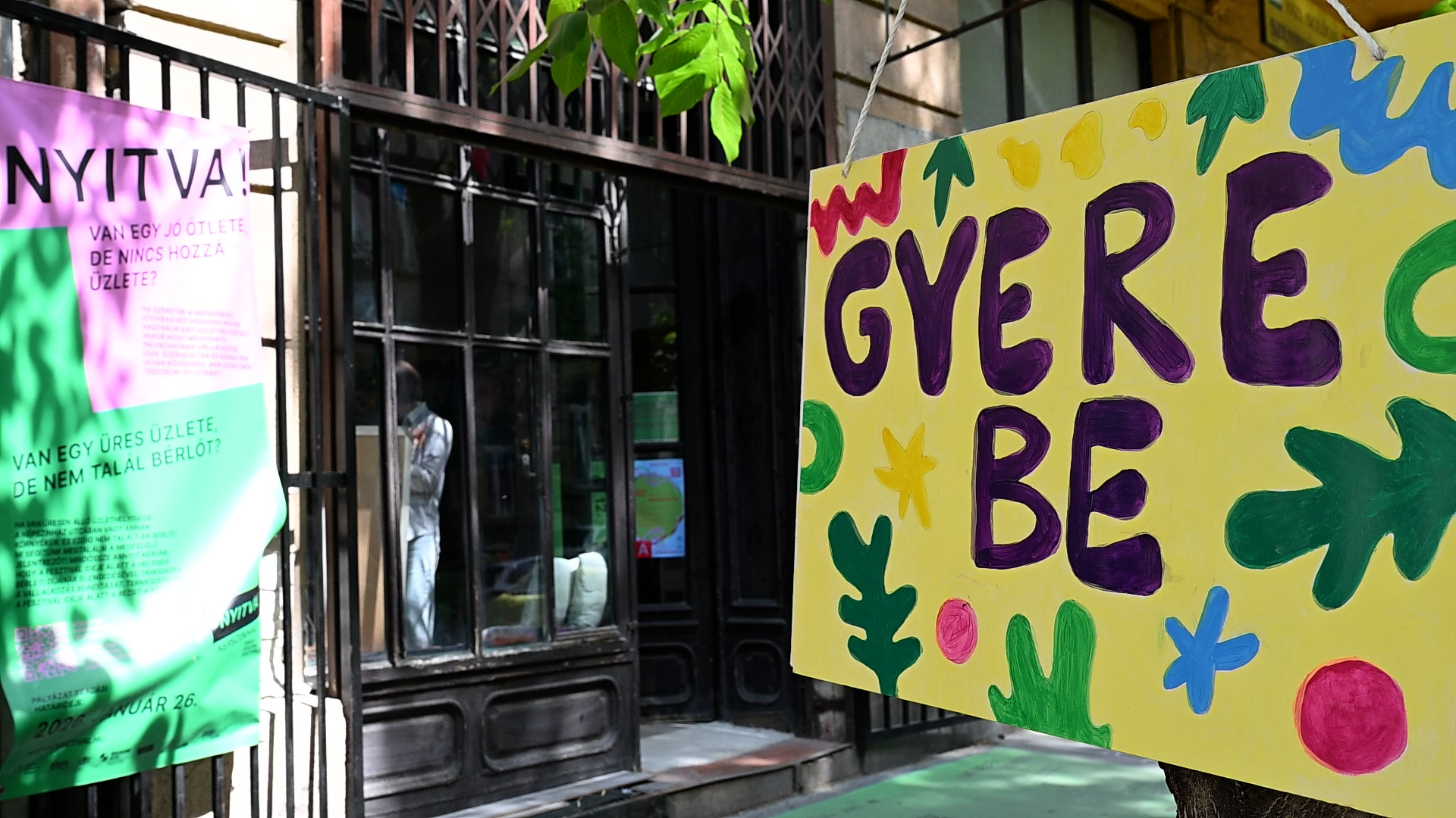 "gyere be" feliratú tábla az utcán