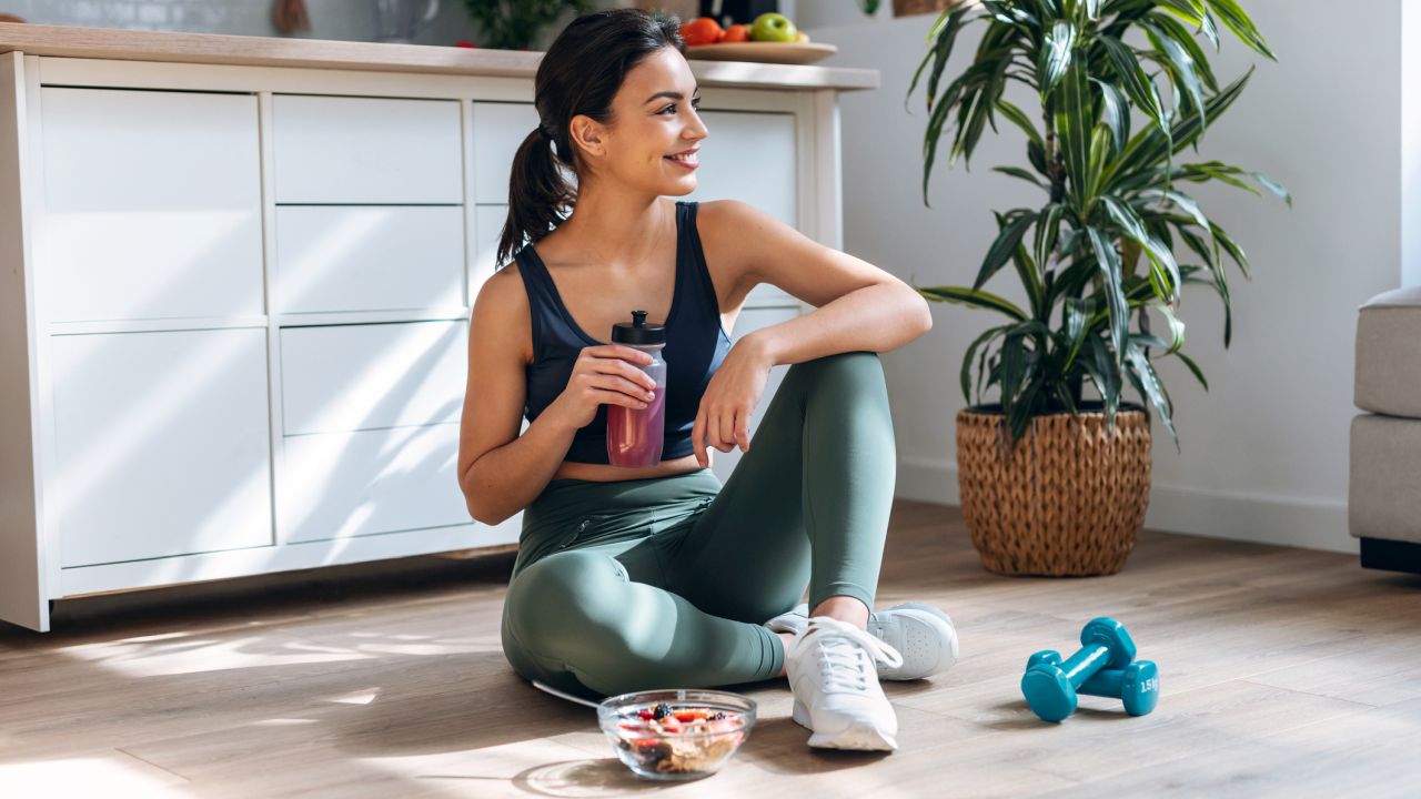 Nő ül edzés után fehérje shake-kel