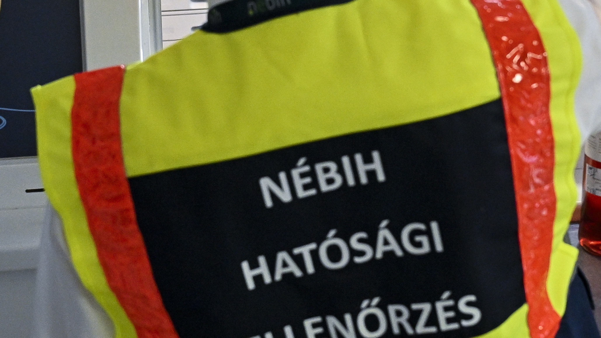 Nébihes mellényben egy ellenőr hátulról