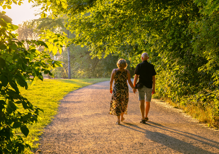 Senior pár sétál kézenfogva a parkban