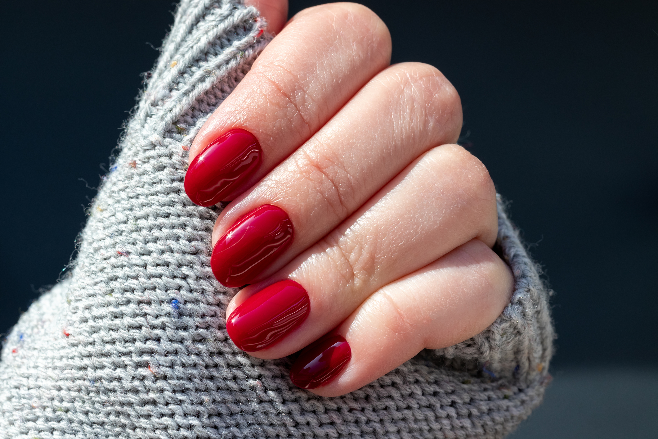 Cseresznyepiros körömlakk női kézen