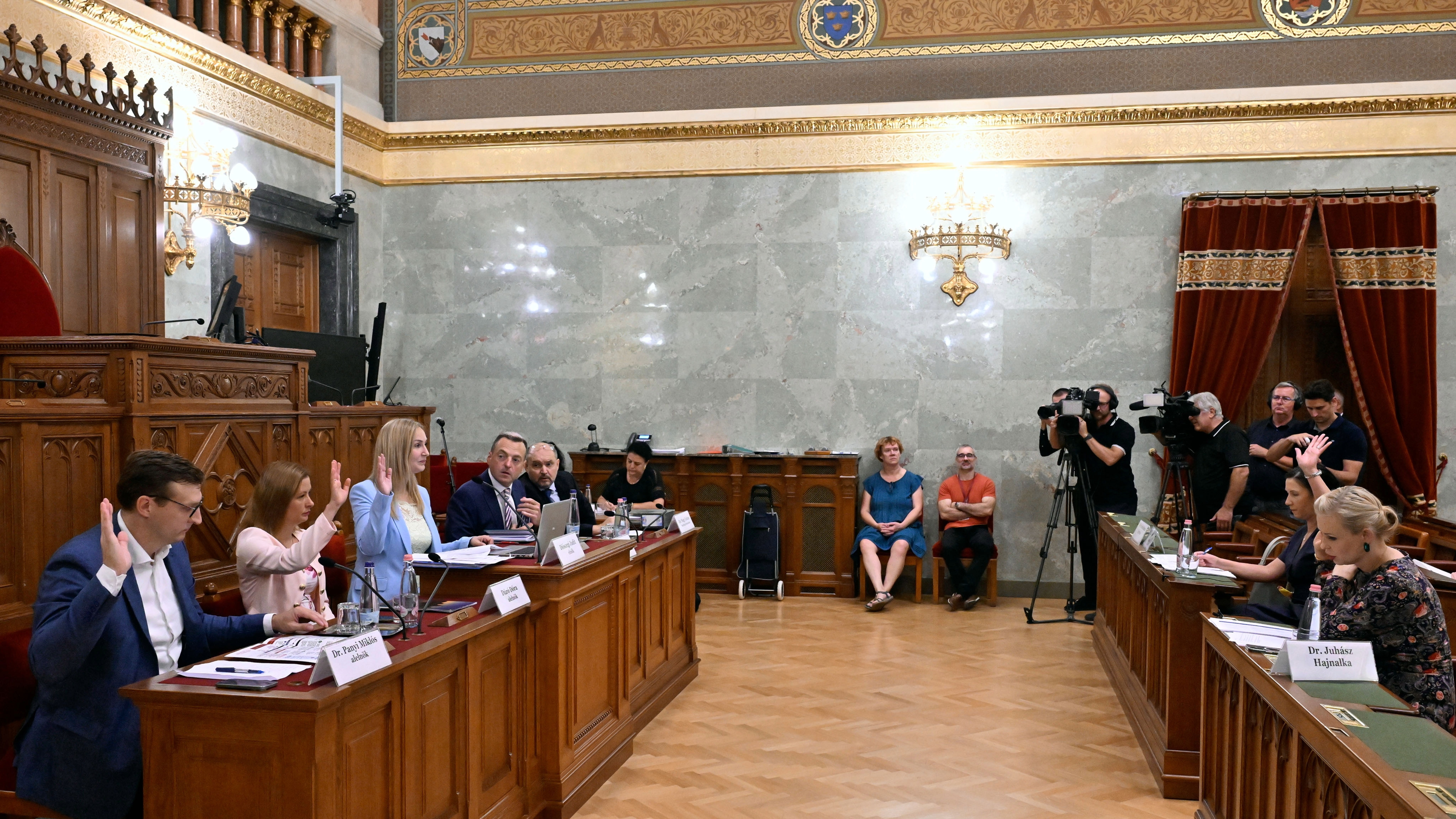 Diószegi Judit, a testület Tisza párti elnöke a gyermekvédelem rendszerszintű válságát feltáró országgyűlési vizsgálóbizottság ülésén az Országházban 2026. augusztus 5-én. Mellette balról Panyi Miklós fideszes és Dúró Dóra Mi Hazánk párti alelnök, jobbról Buksza Zsolt szakmai főtanácsadó és Nagy Zoltán bizottsági munkatárs.
